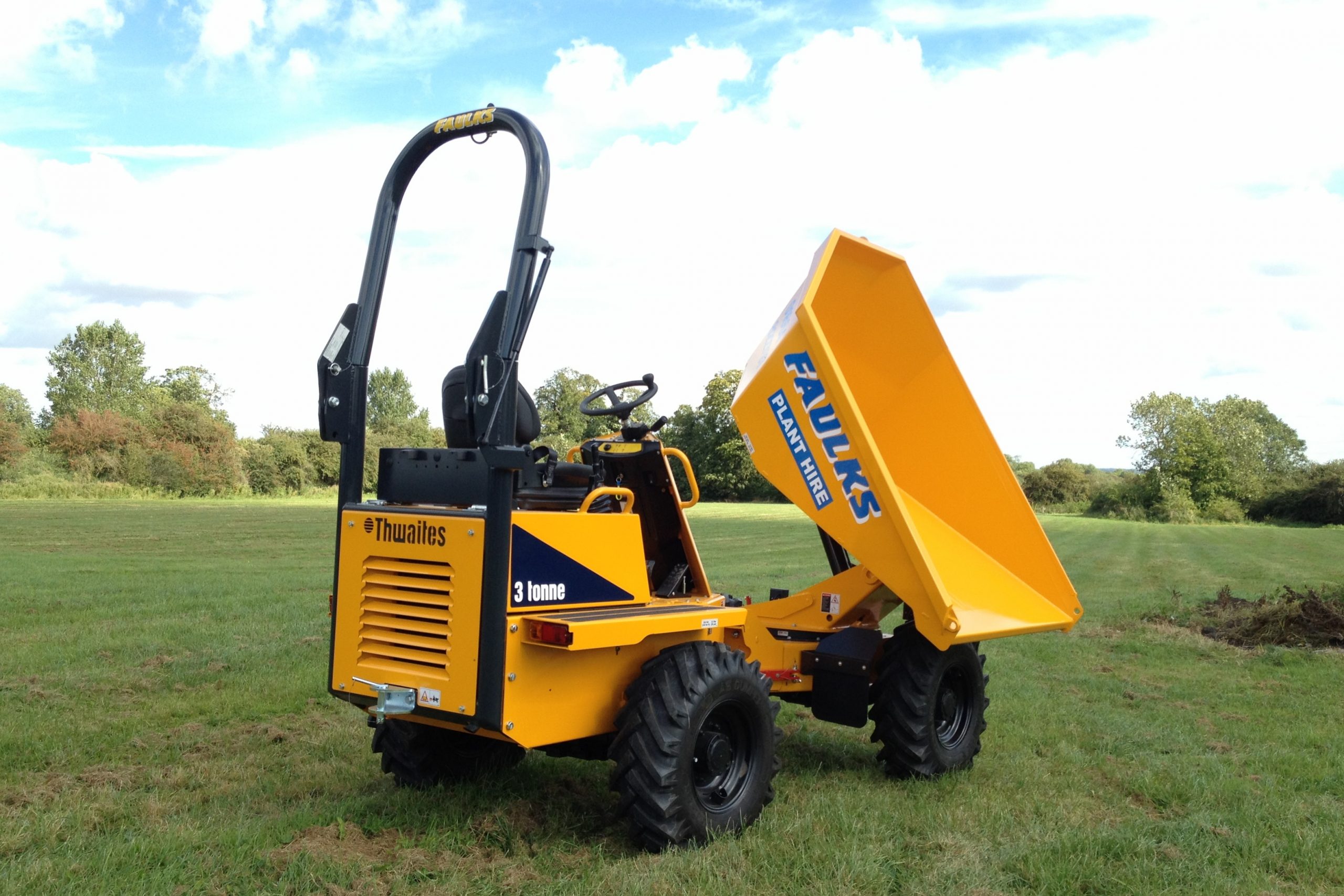 Small thwaites 3 tonne dumper in field with loader raised in topping position