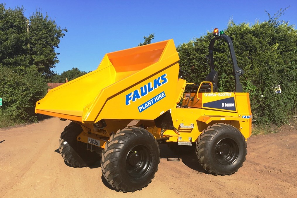 9 tonne dumper from Thwaites in field in front of bushes. One example of front loader dumper hire from AE FAulks