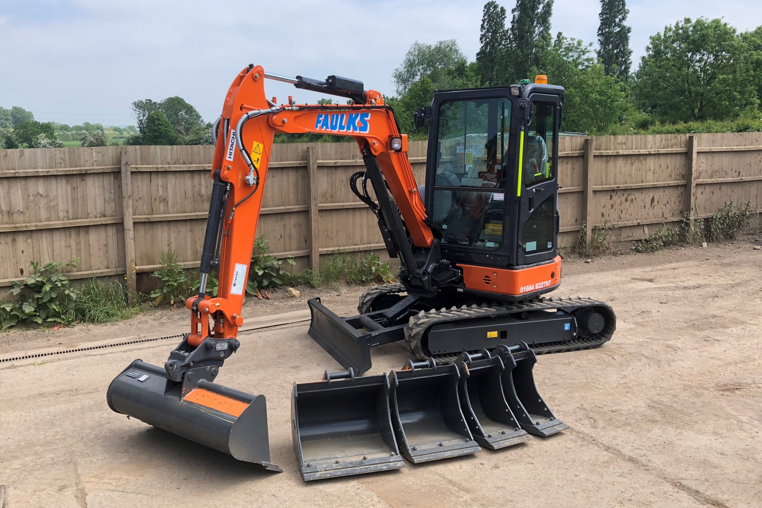 The Hitachi ZX33 tracked excavator in car park with digger head options lined up